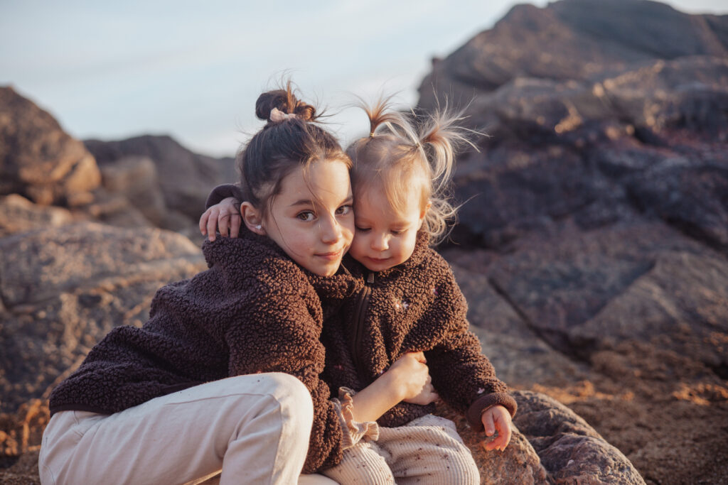 Deux sœurs photographiées sur la plage près des Sables‑d’Olonne, séance famille lifestyle en Vendée.
