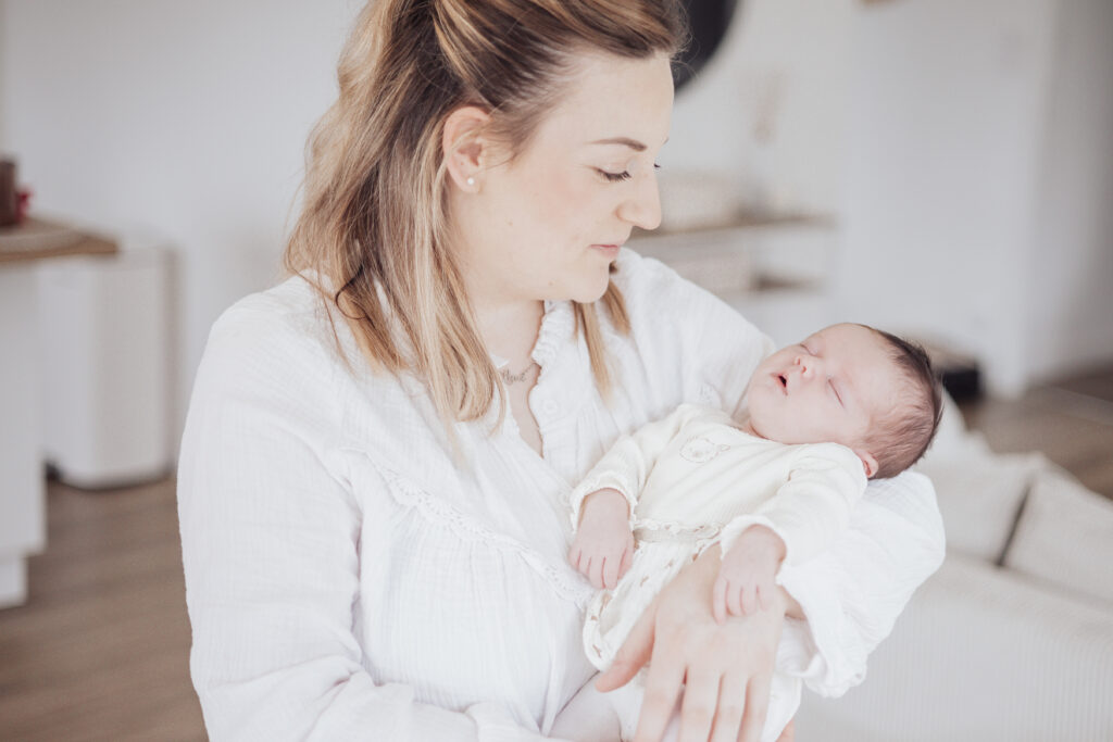 Nouveau‑né dans les bras de son parent, séance photo lifestyle à domicile aux Sables d'Olonne en Vendée.