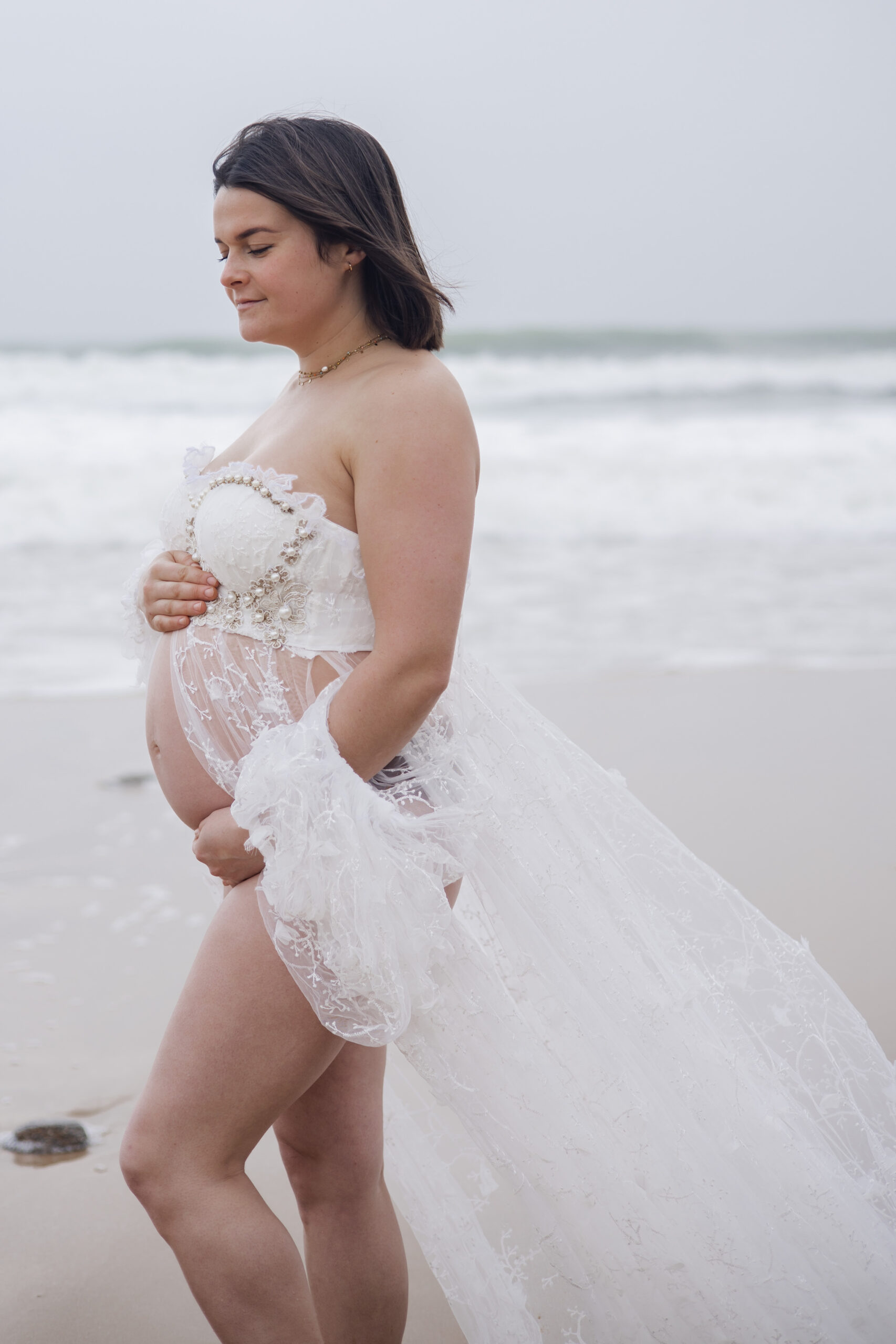 Future maman marchant au bord de l’océan, photographie lifestyle.