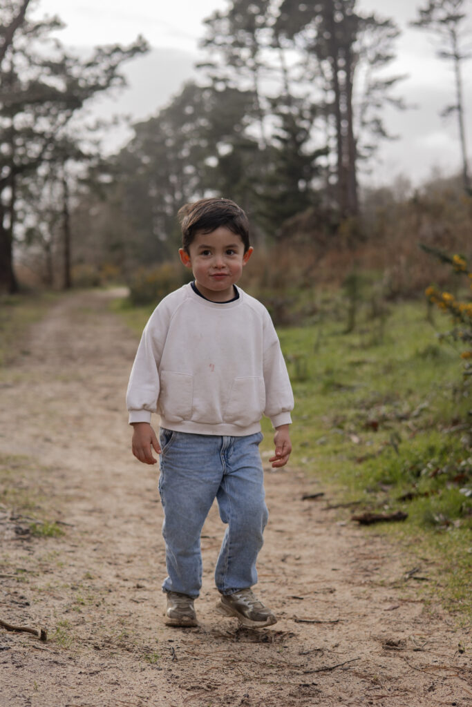 Enfant marchant sur un chemin forestier, moment naturel en extérieur.