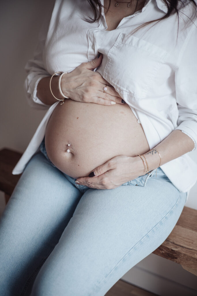 Photo d'un ventre de femme enceinte lors d'une séance lifestyle a domicile.