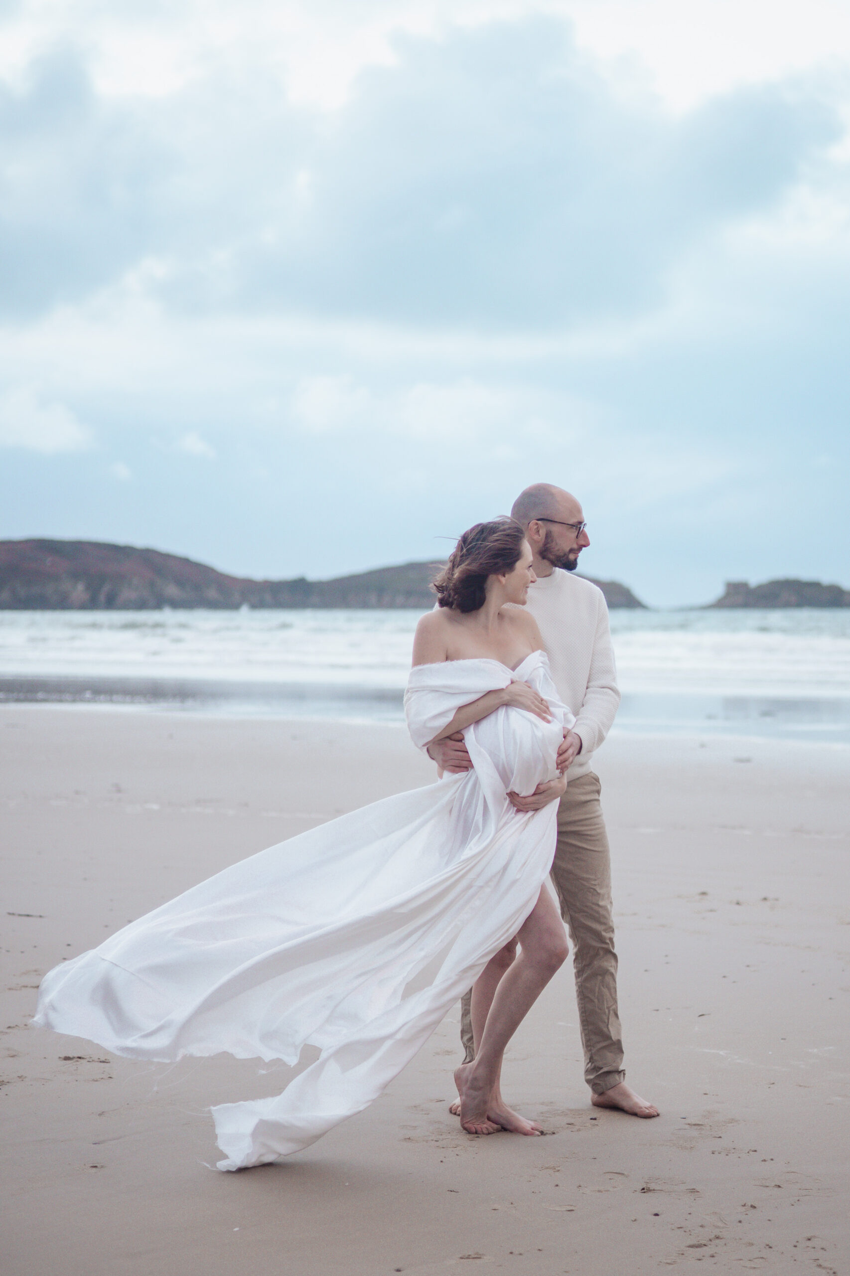 séance photo lifestyle en exterieur a la plage avec un couple pendant une séance grossesse
